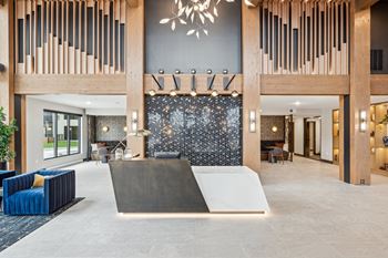 A modern lobby with a black and white patterned wall and a large wooden structure.